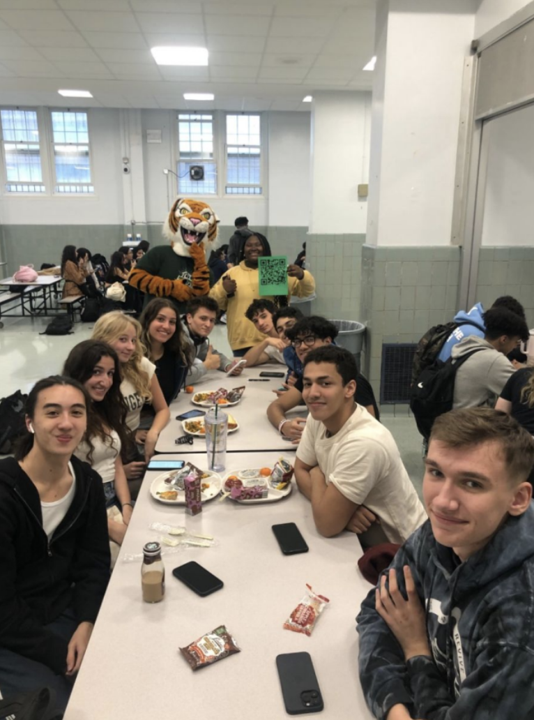 Students in the cafeteria pose with the the tiger mascot for Earth Week. Photo provided by Toni Rosario.